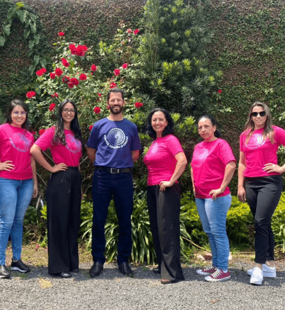 Equipe da Gelinski Contabilidade reunida na área externa do escritório, com camisetas da campanha Outubro Rosa